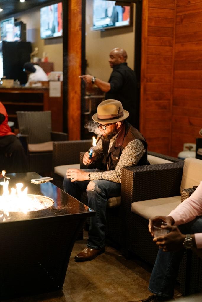 Guest enjoying a cigar at the Downtown Cigar Company fire pit lounge