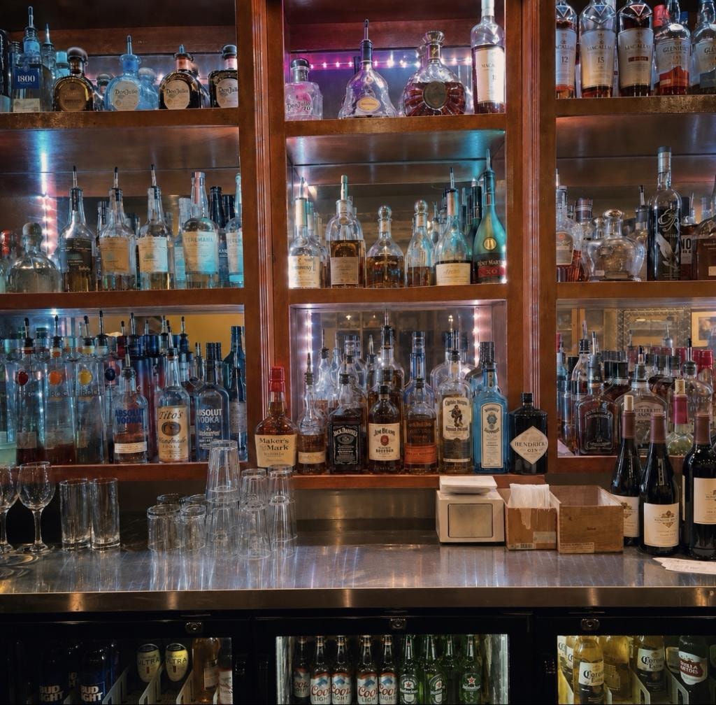 Downtown Cigar Company full back bar with illuminated wooden liquor cabinets and extensive bottle selection