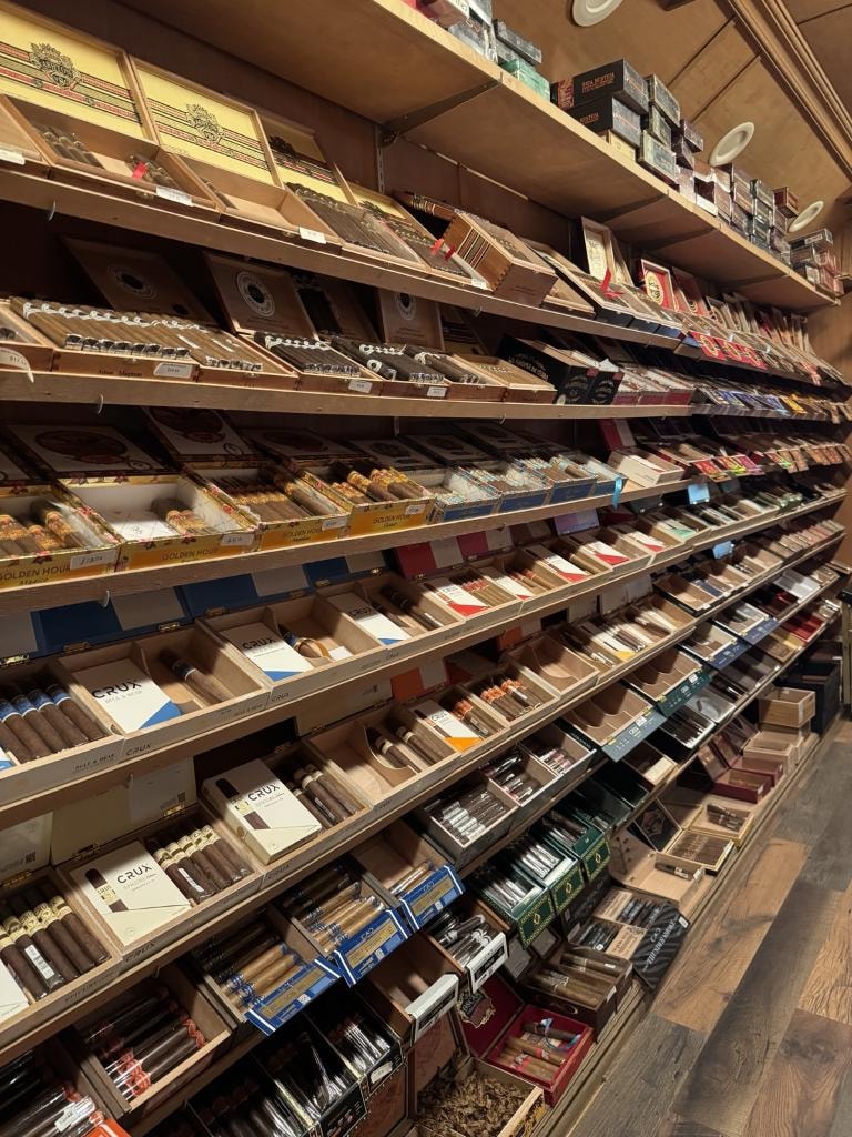 Downtown Cigar Company humidor wall with rows of premium cigar brands including Crux